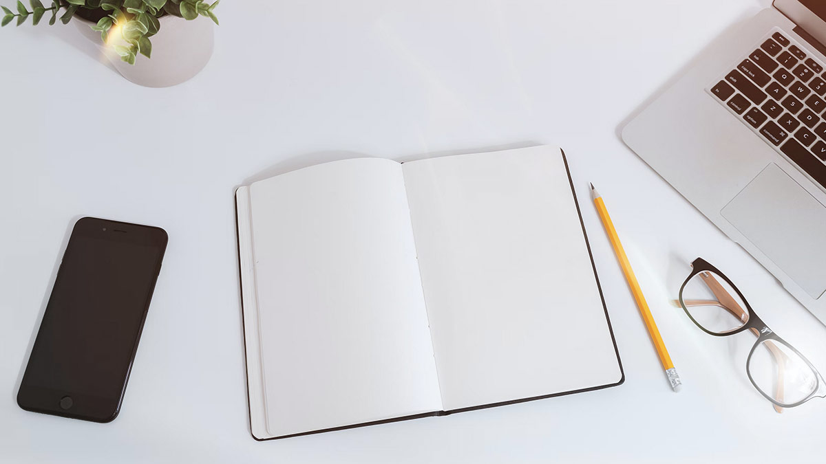 Photo d'un carnet de note avec un laptop sur un bureau