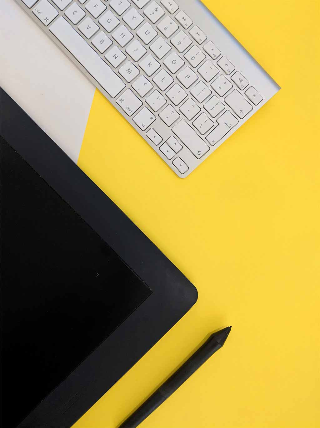 Photo clavier et tablette posées sur un fond jaune