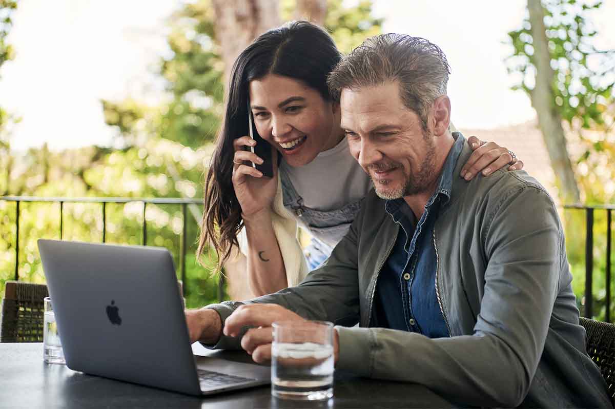 Photo d'un couple souriant devant un ordinateur'