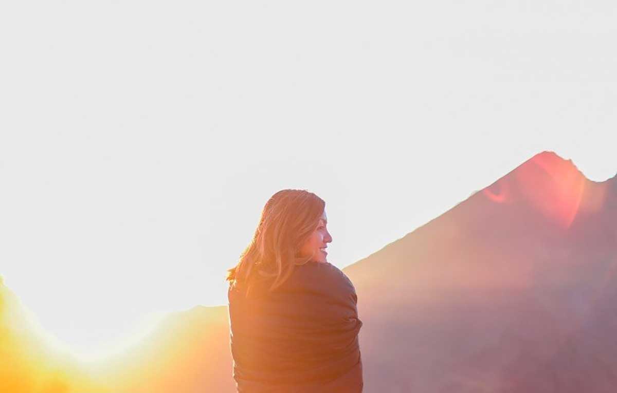 Photo d'un femme devant un couché de soleil