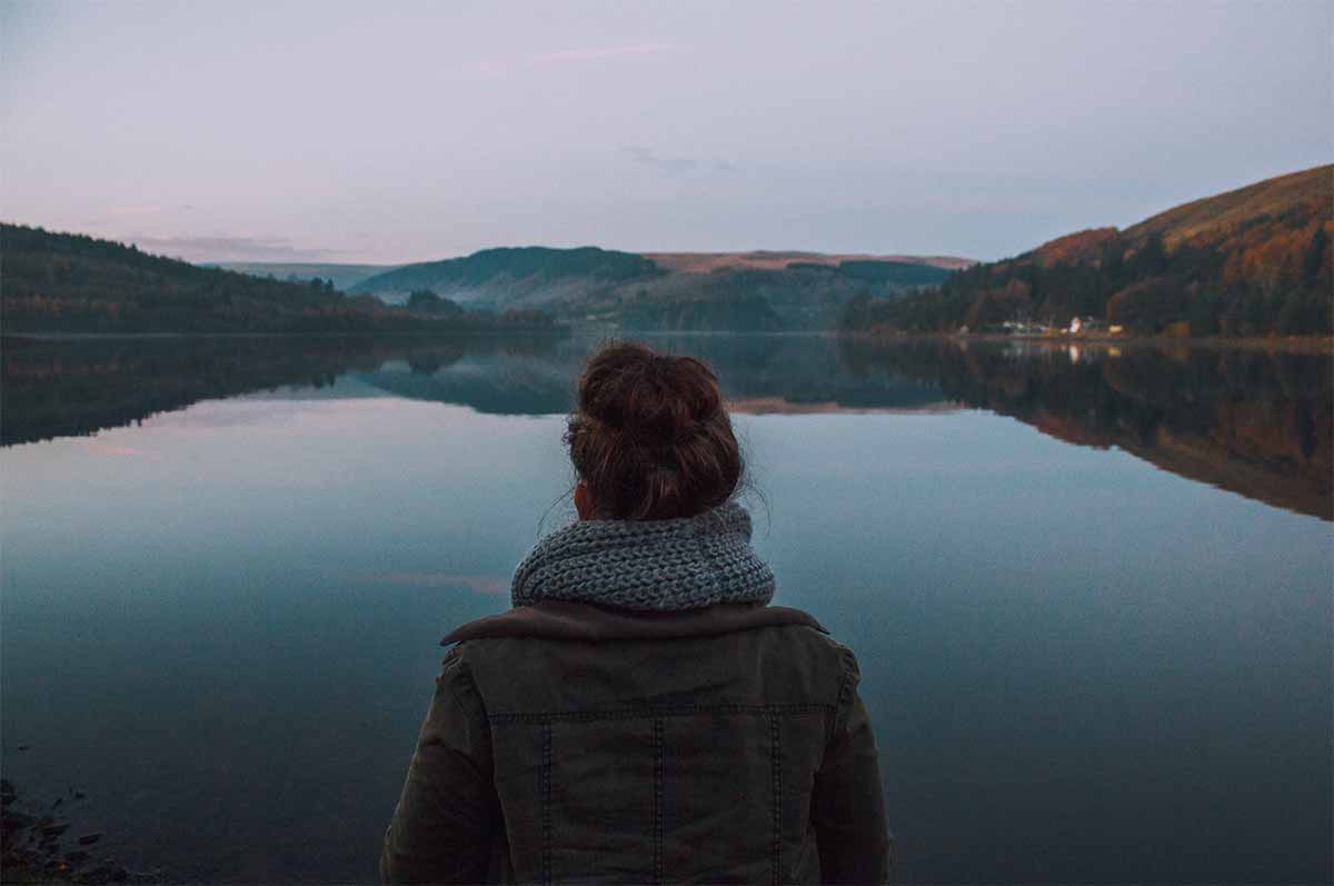 Photo d'une femme regardant regardant un lac pendant le crépuscule