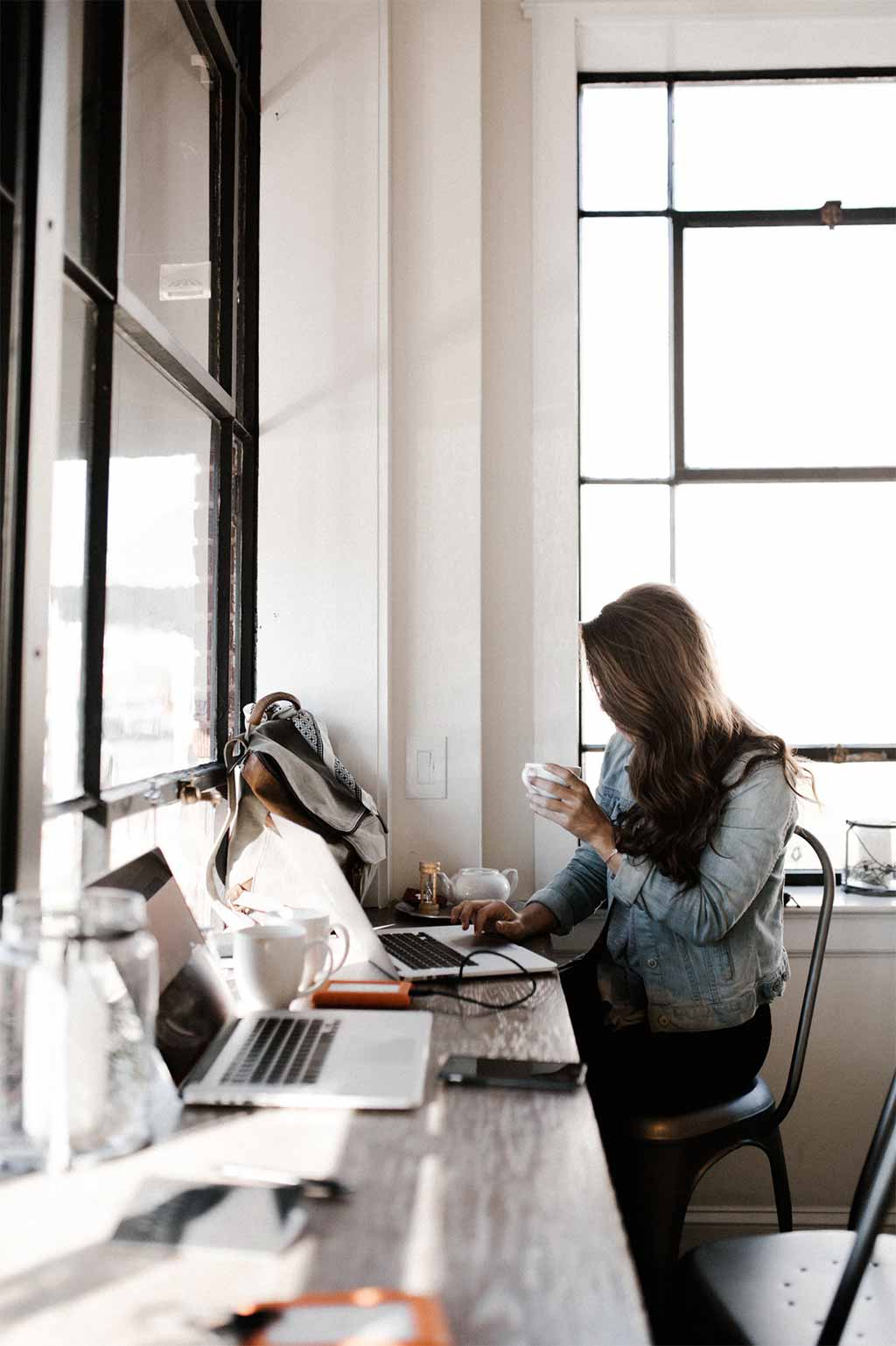 Photo femme avec une tasse devant un ordinateur