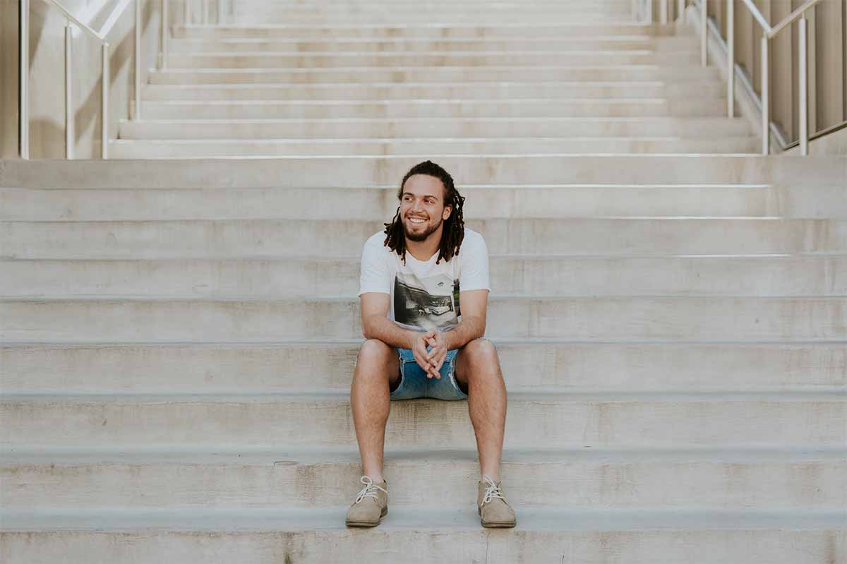 Photo homme souriant assis sur des marches