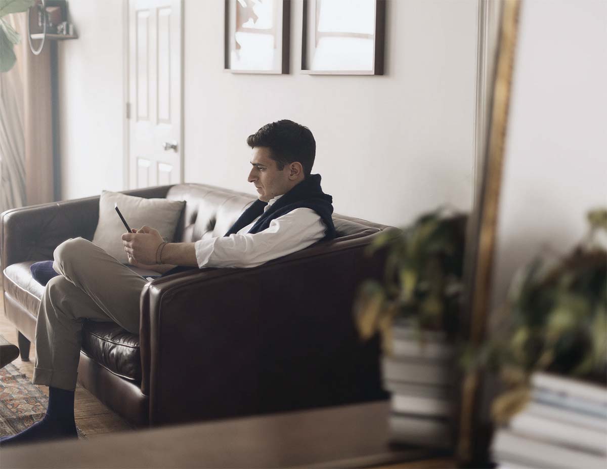 Photo d'un homme utilisant son téléphone sur son canapé