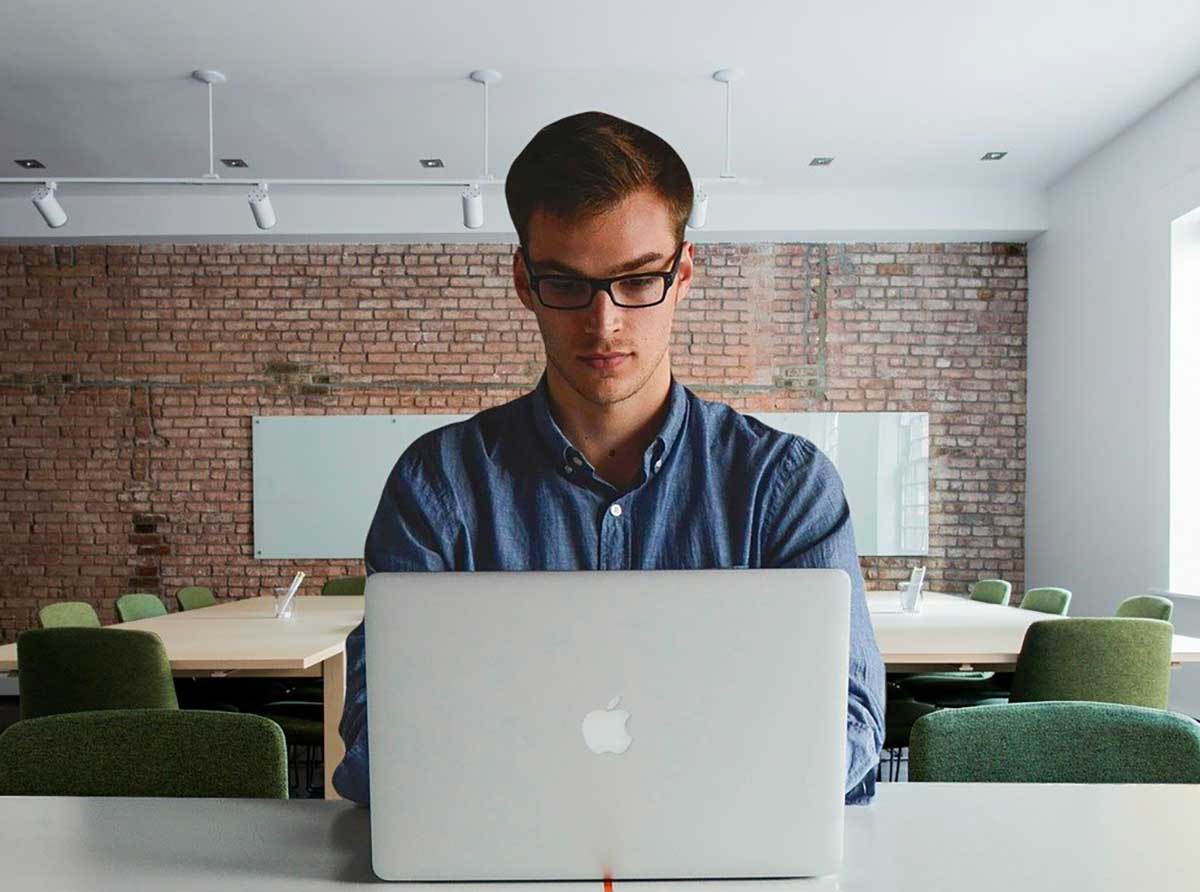 Photo d'un jeune homme devant un mackbook