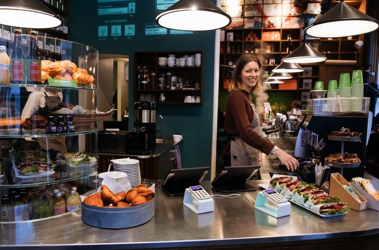 Photo terminal de paiement Izettle dans une boutique avec une commerçante souriante