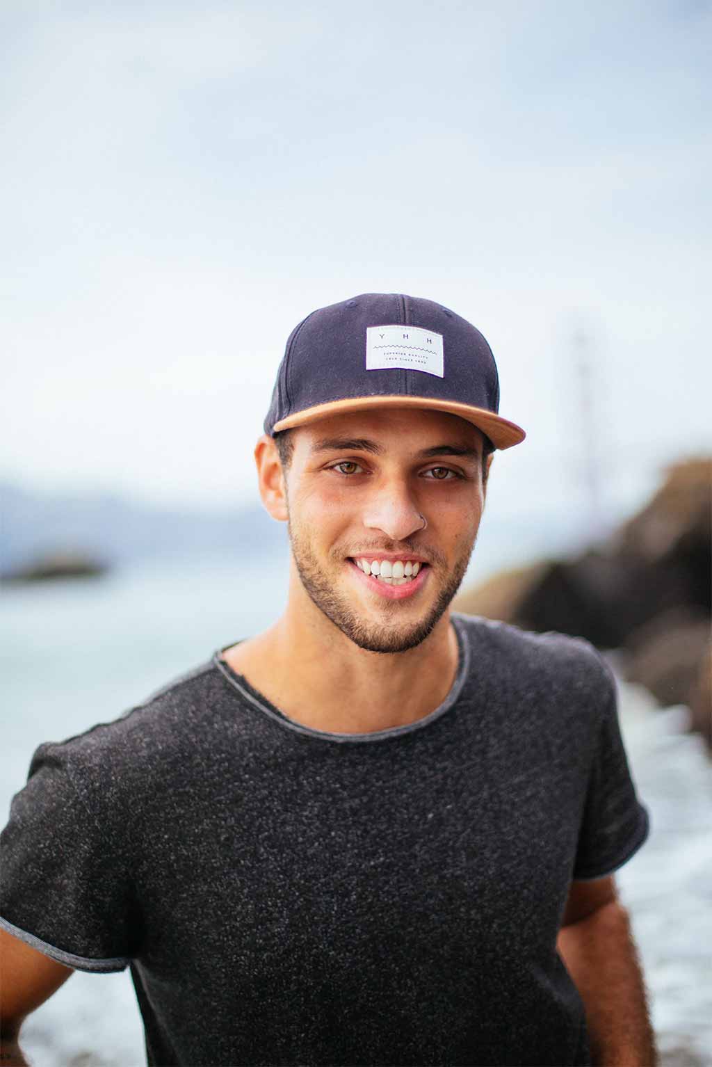 Photo portrait jeune homme avec une casquette et souriant