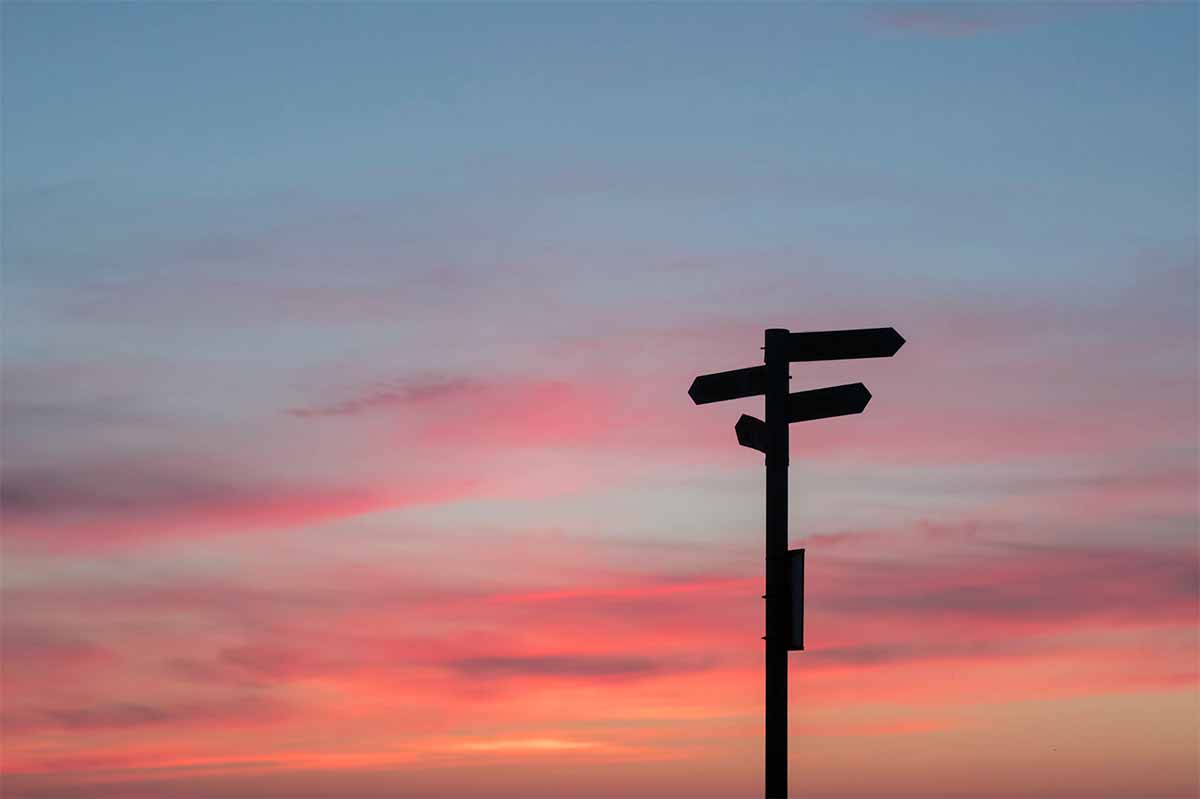 Photo ciel au crépulscule avec un panneau de direction en contre jour