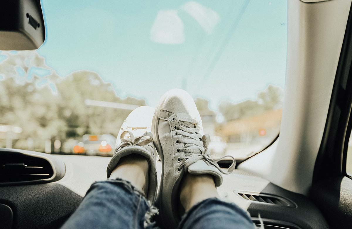 Photo d'un jambes sur le tableau de bord côté passager