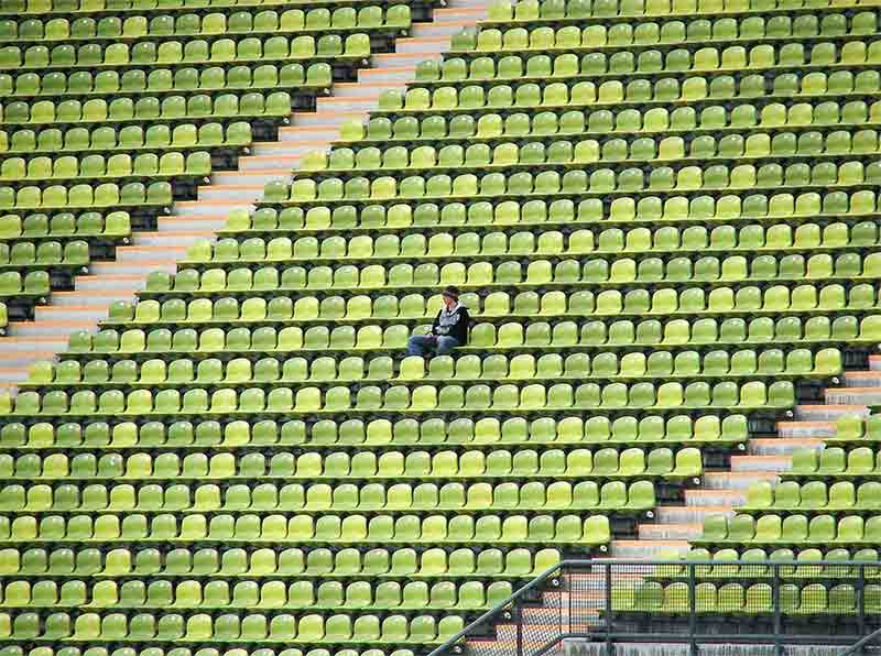 Photo d'un jeune homme assis au milieu de sièges vides
