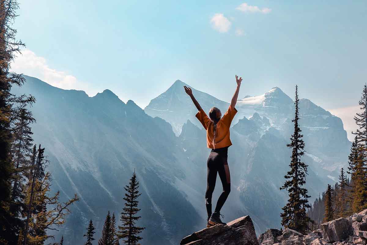 Photo d'une femme levant les mains à la montagne